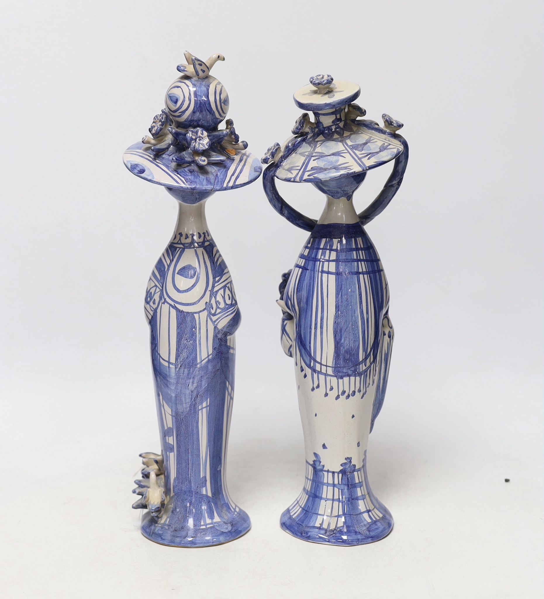 Two Bjørn Wiinblad, Denmark, blue and white ceramic female figures with large hats, 34.5cm